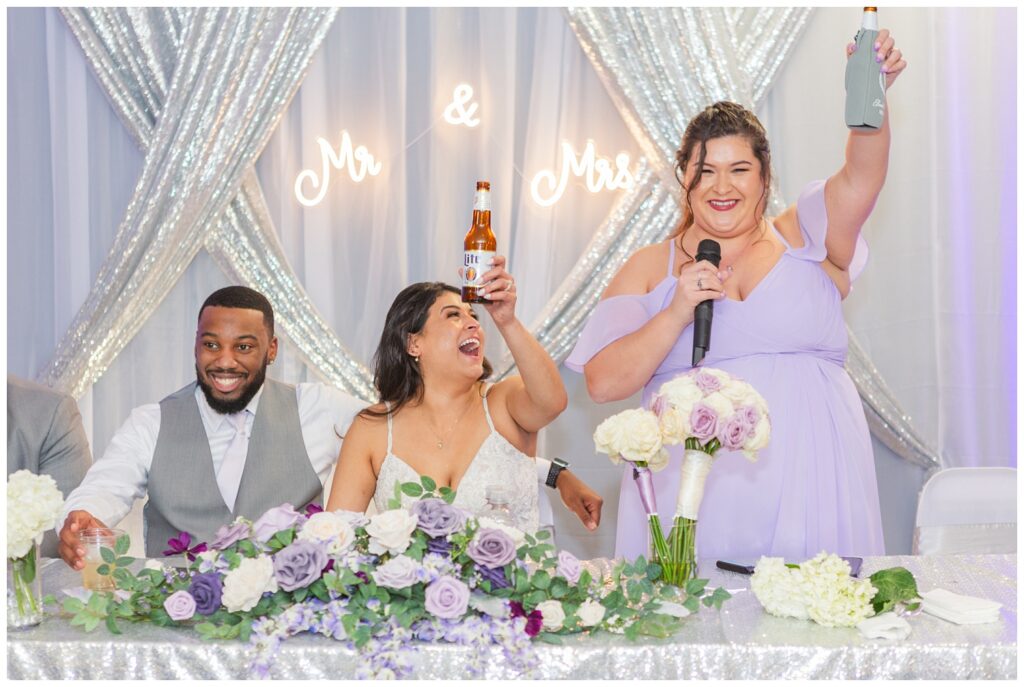 bride cheering with bridesmaid at reception table in Fremont, Ohio