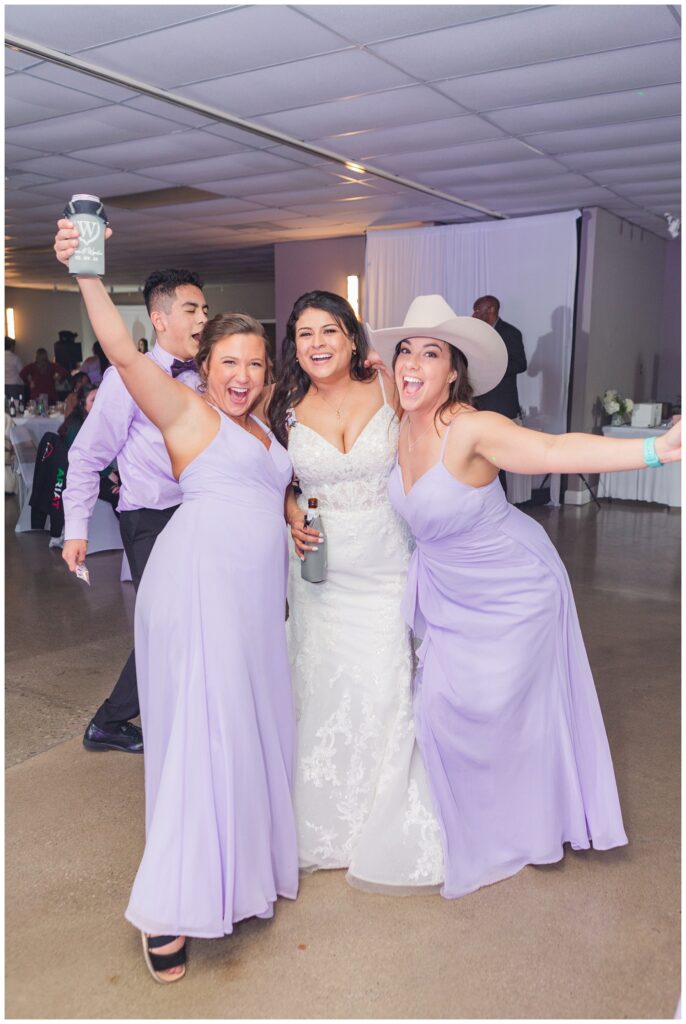 bride posing and laughing with her bridesmaids at wedding reception 