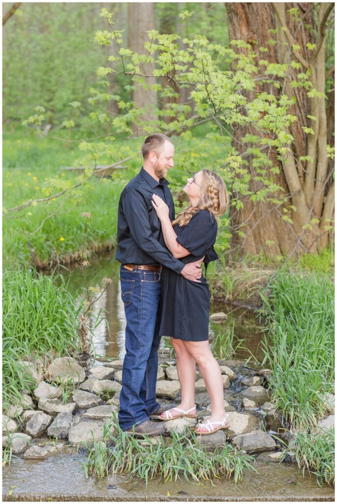 engagement couple posing near a creek at Norwalk Reservoir in Tiffin, Ohio