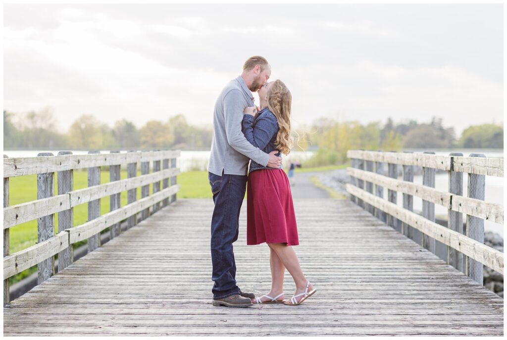 engagement couple kissing on the boardwalk at Norwalk Reservoir 