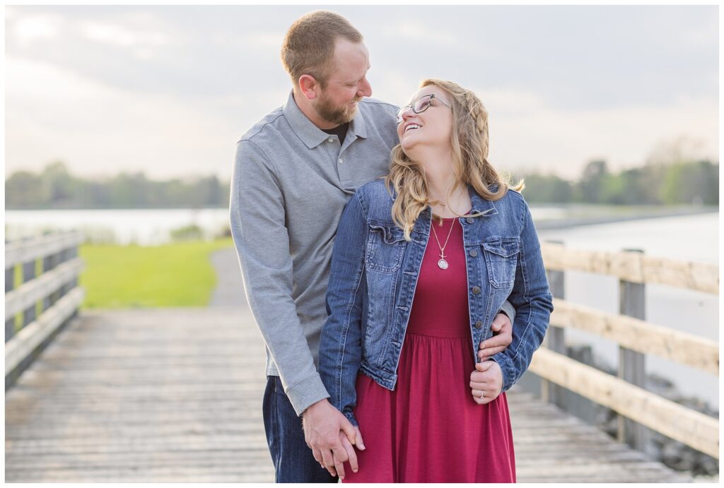 couple laughing near the lake at Norwalk Reservoir engagement session