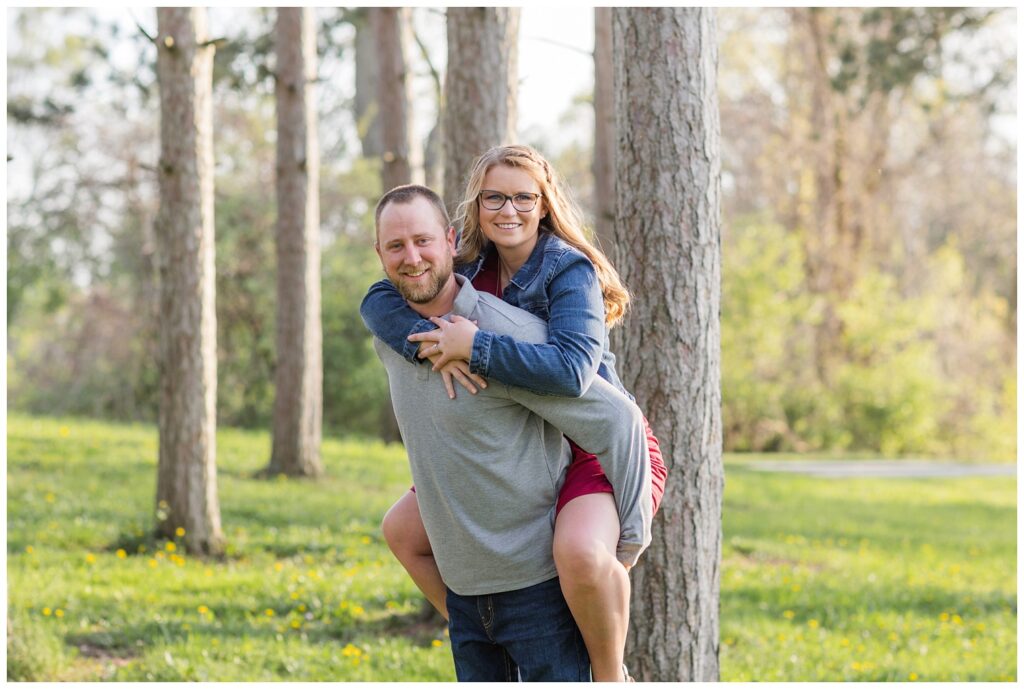 couple posing near a grove of trees at Tiffin, Ohio engagement session