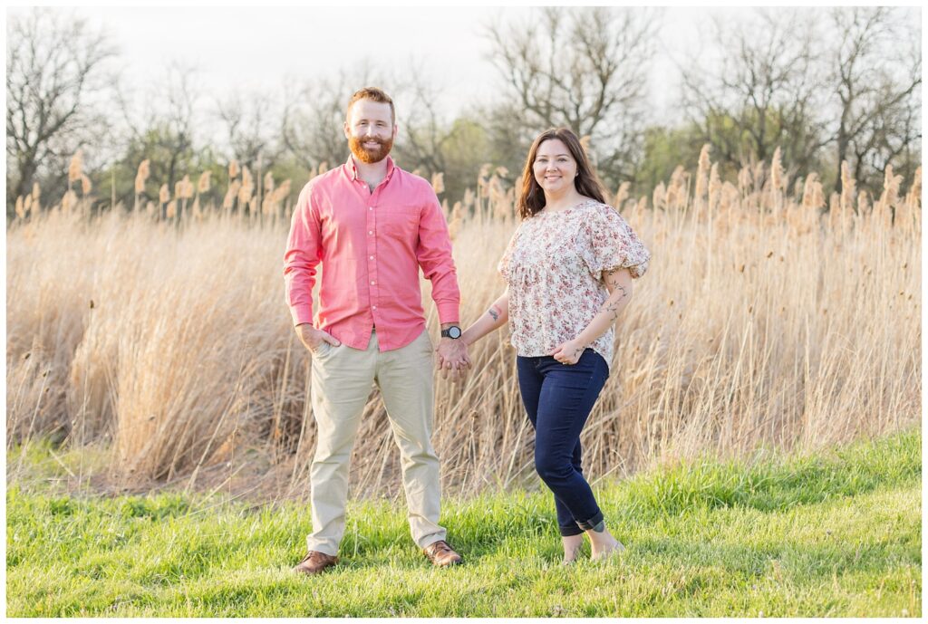 couple posing and holding hands in front of a wheat field in Lindsey, Ohio