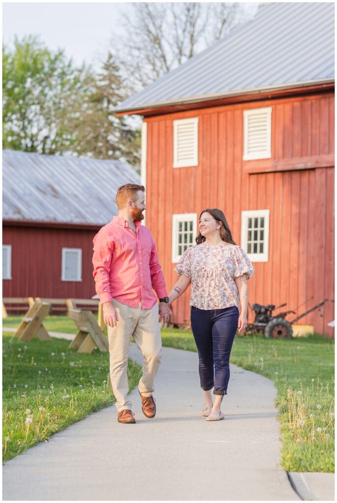 couple walking in front of a red barn at Creek Bend Farm