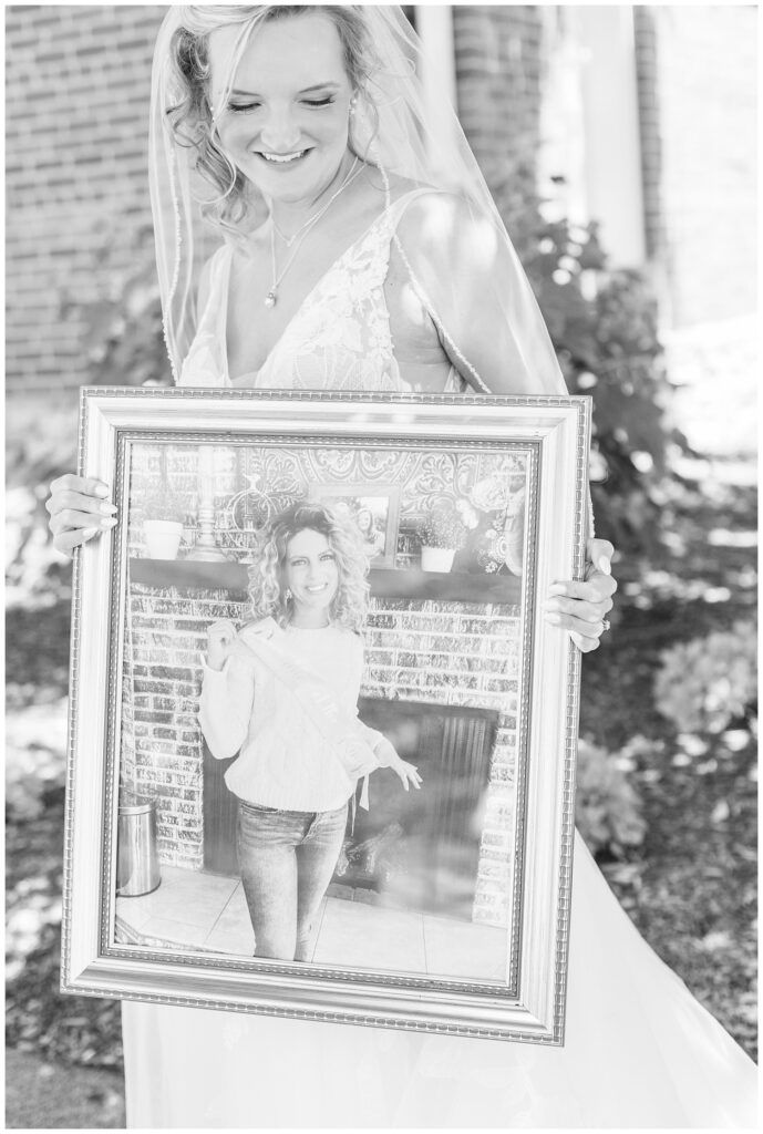 bride holding a large framed portrait of her mom before her wedding in West Mansfield, Ohio