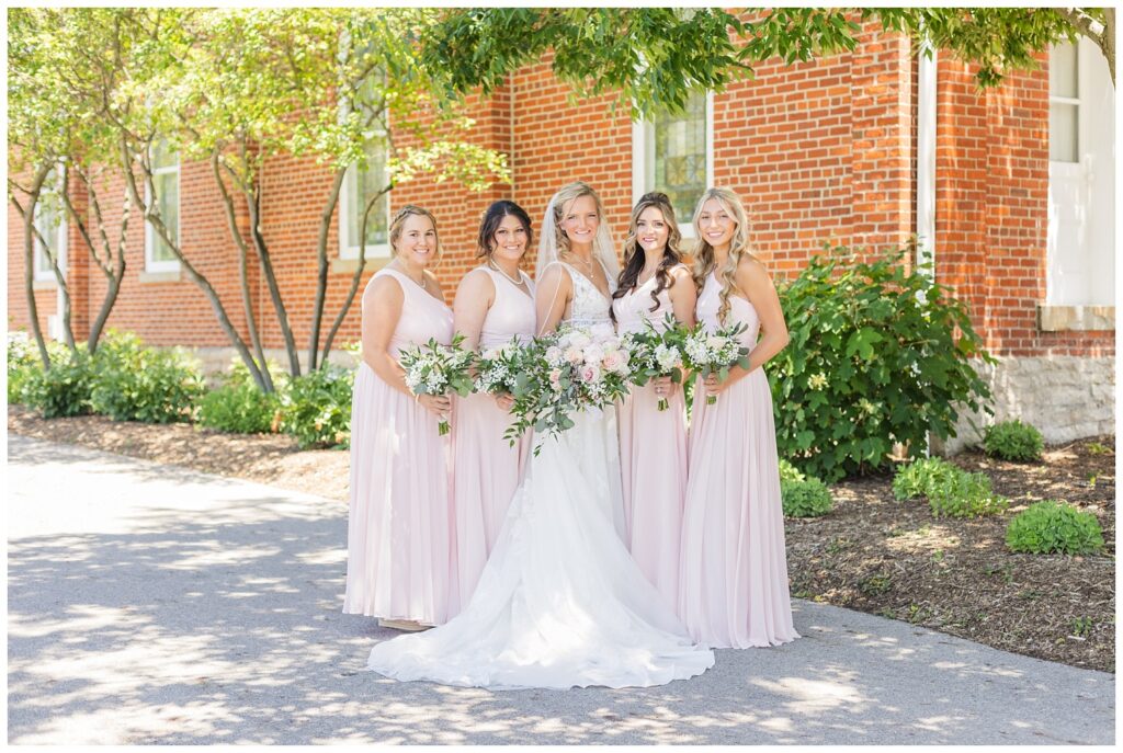 bride with bridal party posing outside under the trees in Dublin, Ohio