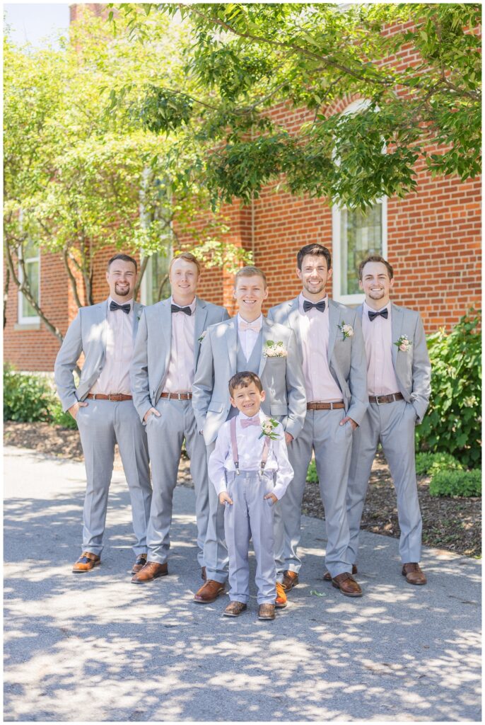 groomsmen and ring bearer posing outside with the groom before the wedding ceremony