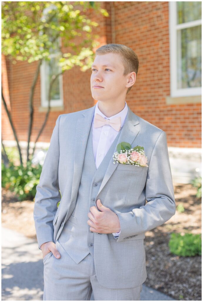 groom posing with his hand in his pocket and hand on jacket before wedding ceremony