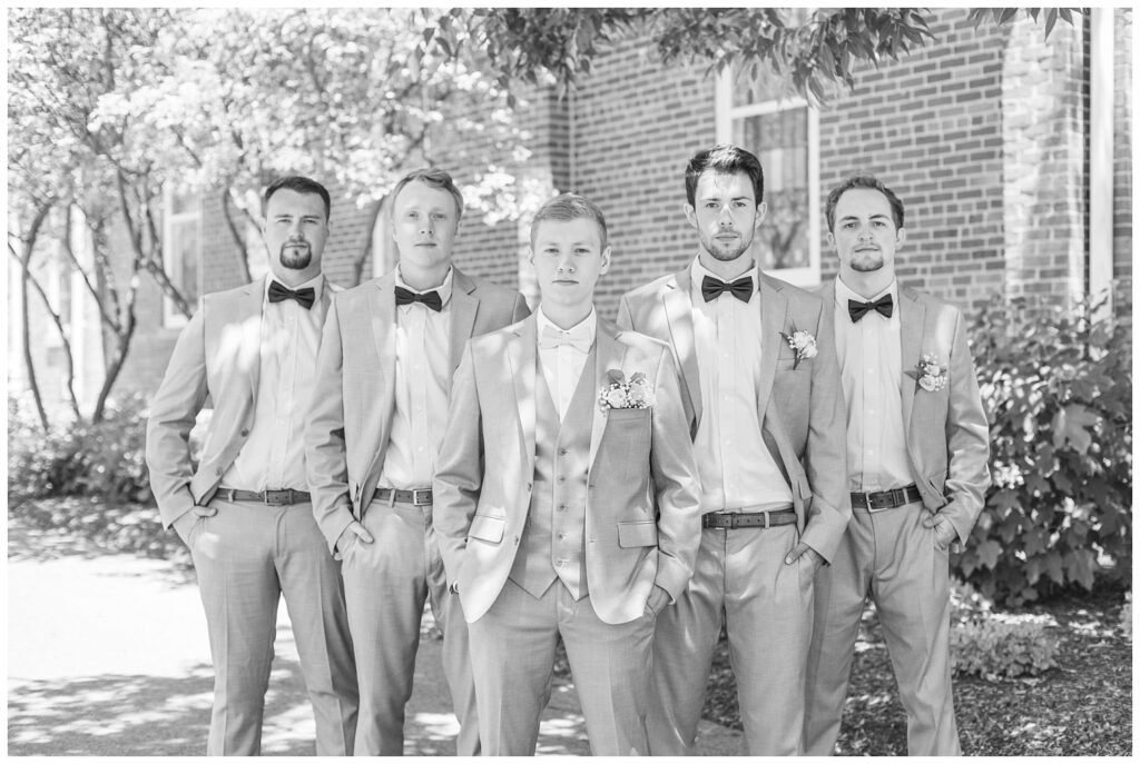 groom and groomsmen posing with a serious look outside the church in Dublin, Ohio