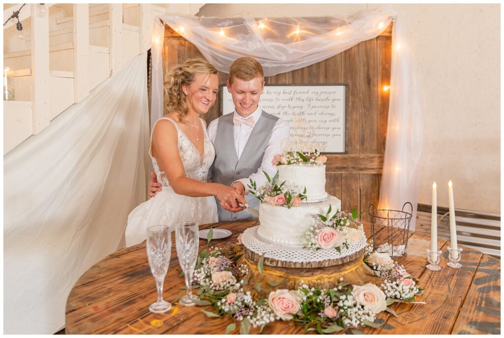 wedding couple cutting the cake together at Prairie Stone Farm venue reception