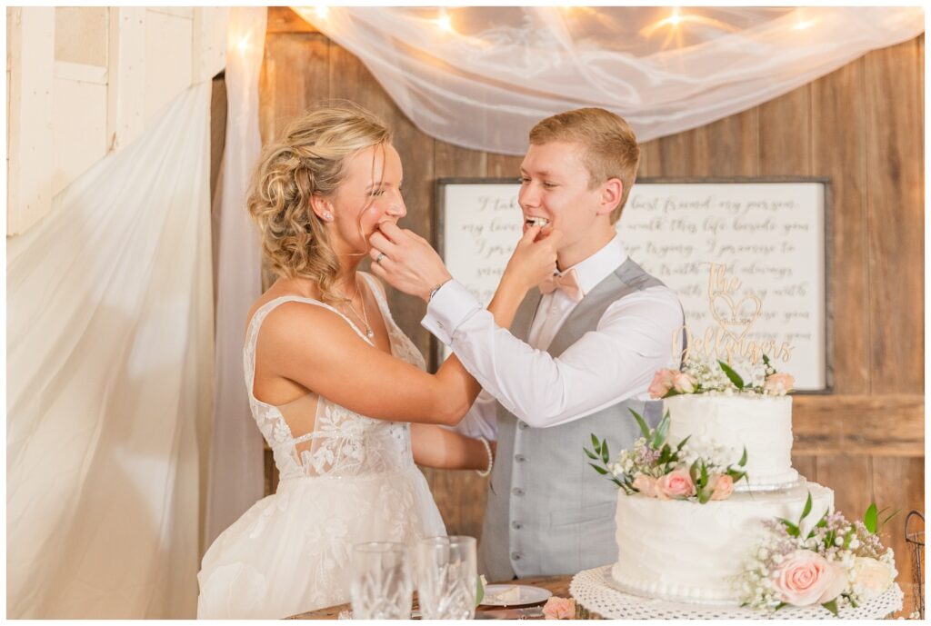 wedding couple feeding each other cake at Prairie Stone Farm venue reception