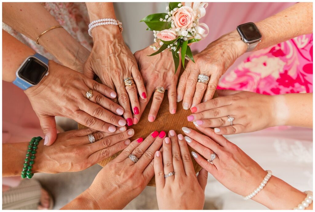 bride and her female family members all showing off their wedding rings at barn reception