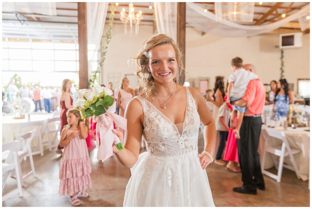 bride about to toss her bouquet at barn wedding reception in West Mansfield, Ohio