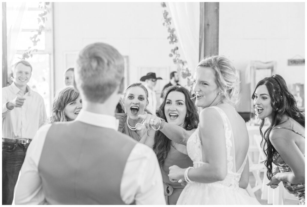 wedding guests laughing at the groom during Prairie Stone Farm venue reception