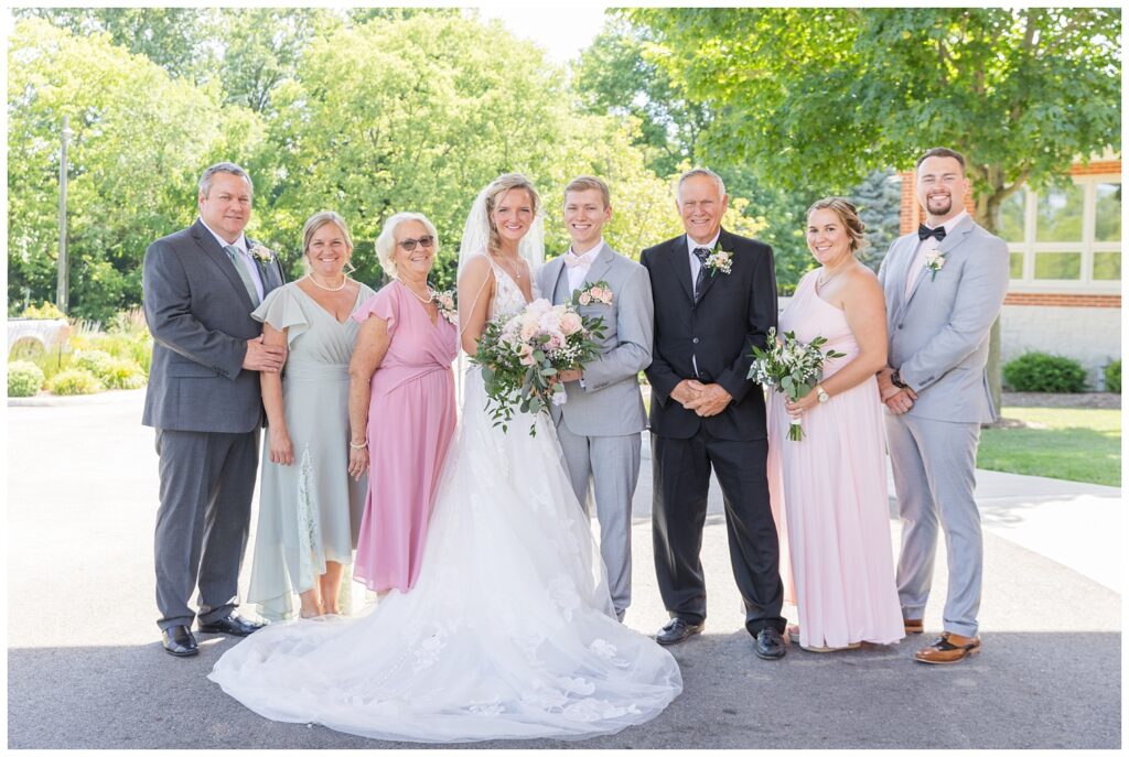 groom and bride posing with the groom's family after a summer wedding in Ohio