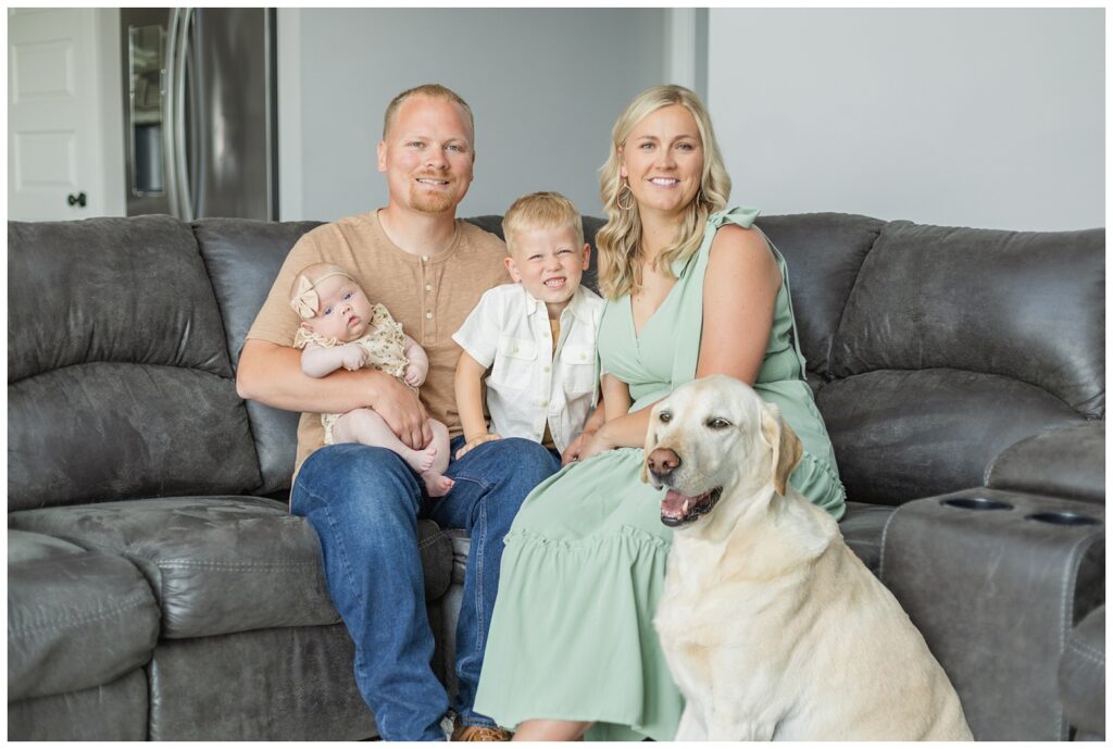 family sitting on a couch for lifestyle newborn family session in Tiffin, Ohio