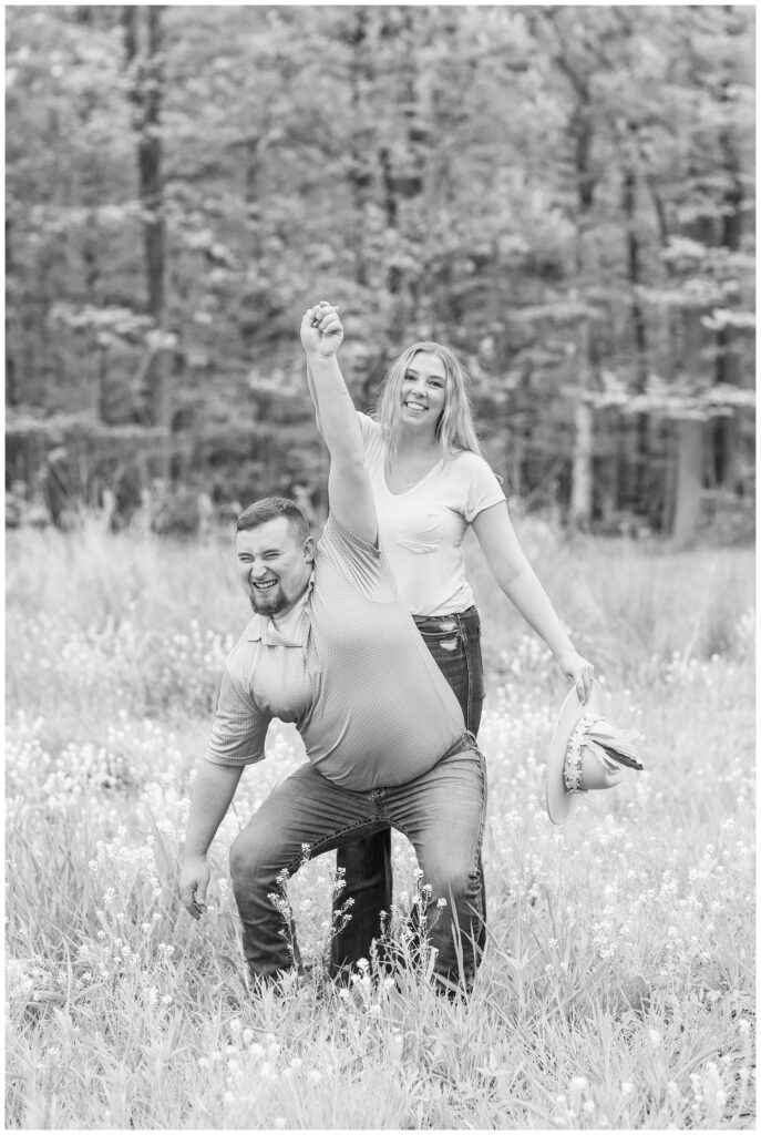 woman twirling her fiance and laughing in a yellow flower field in Willard, Ohio