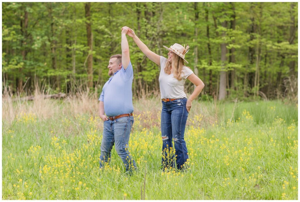 woman twirling her fiance in a yellow flower field in Willard, Ohio