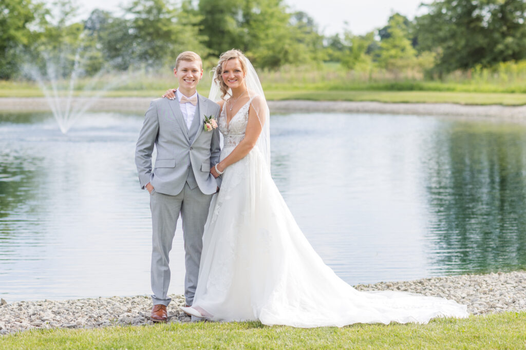 wedding couple posing in front of a pond at Prairie Stone Farm