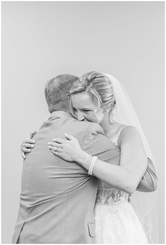 bride hugging her dad during first look at the church before the wedding 