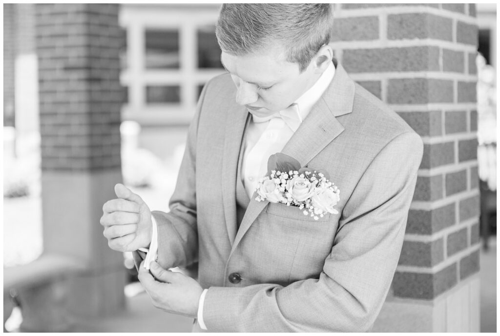 groom adjusting his cufflinks outside at the church in Dublin, Ohio