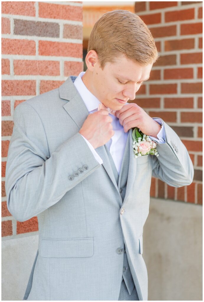 groom adjusting his bowtie outside at the church in Dublin, Ohio