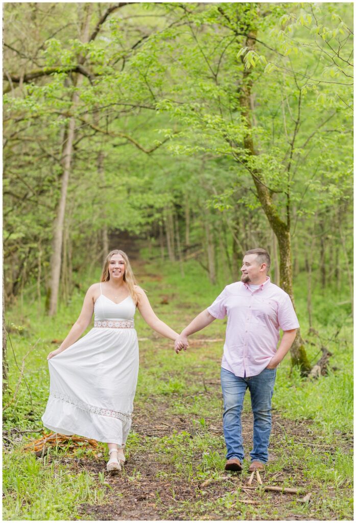 couple walking together in the woods at Willard, Ohio engagement session