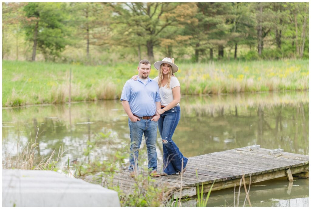 engaged couple standing on a dock on top of a pond in Willard, Ohio