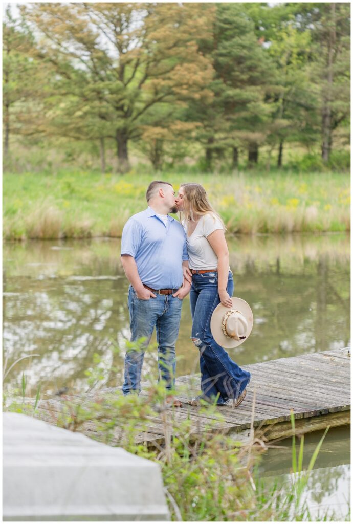 engagement couple sharing a kiss on a dock in Willard, Ohio