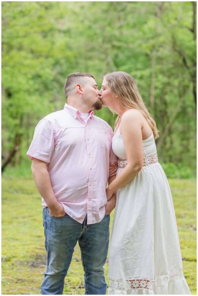 couple sharing a kiss on a moss covered  bride in Willard, Ohio