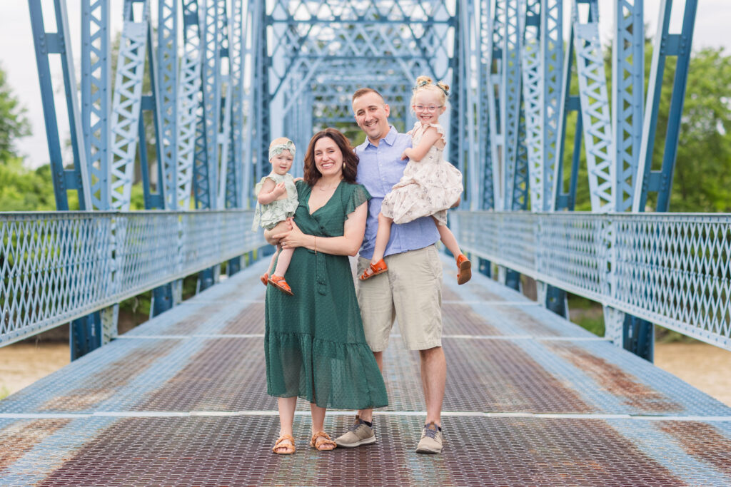 family session of four standing on a blue metal bridge in Fremont, Ohio