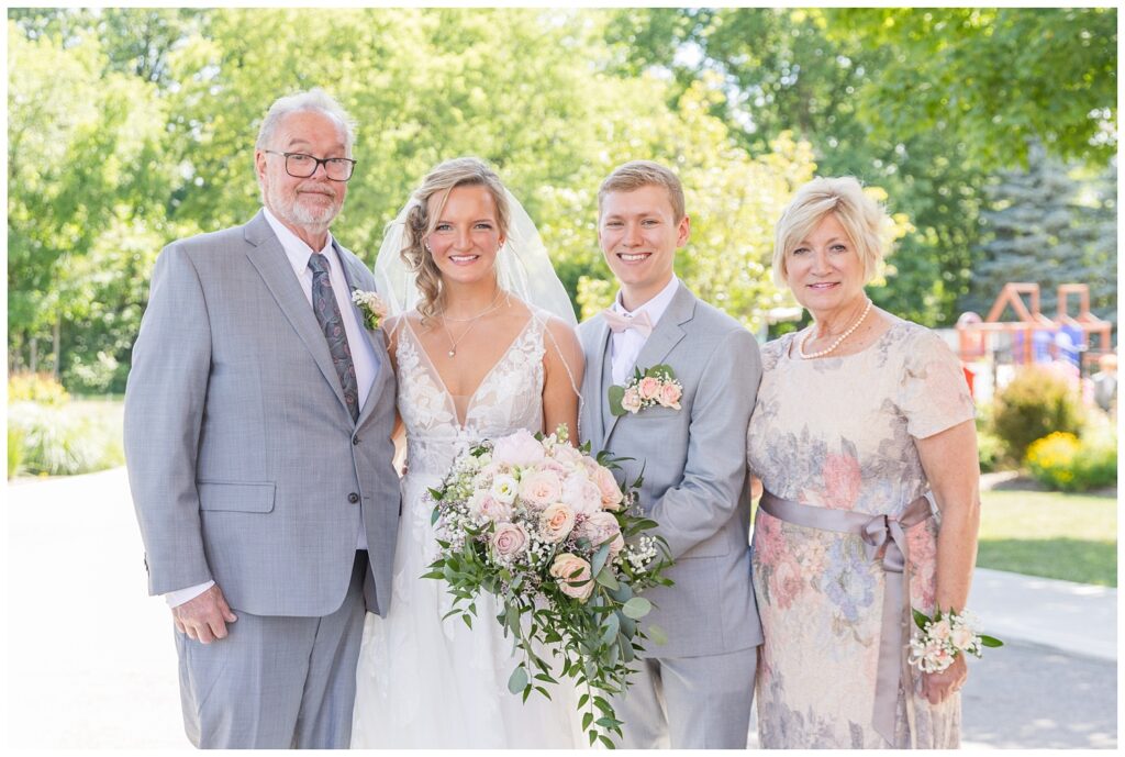 bride and groom pose with family outside the church after wedding ceremony