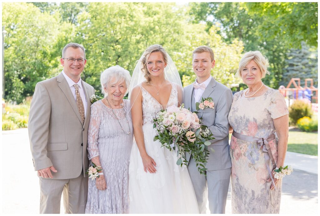 groom and bride posing with the bride's family after the wedding in Dublin, Ohio