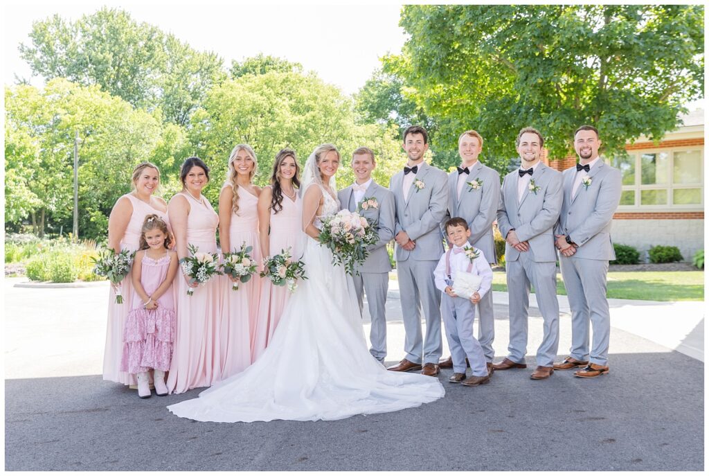 full wedding party posing together at the church after the ceremony in Ohio