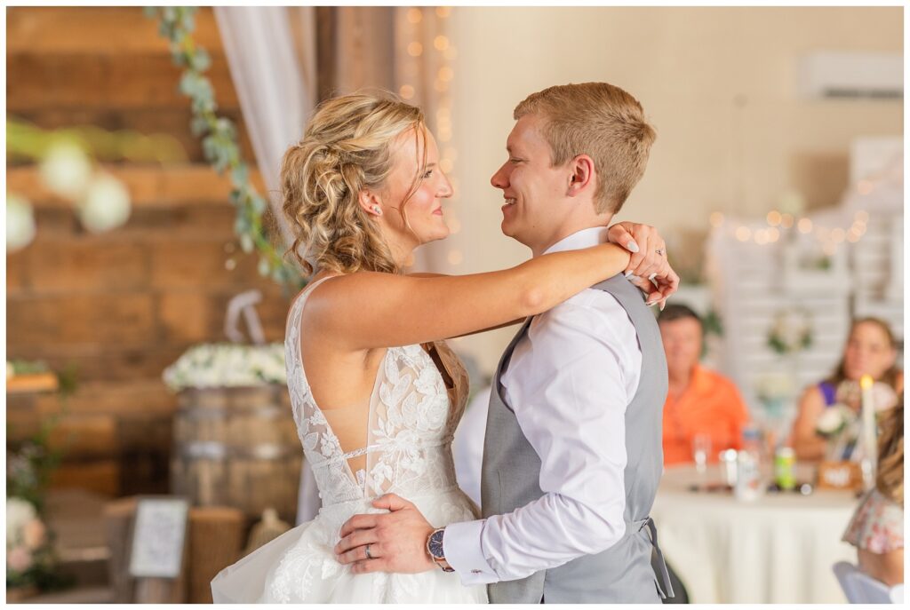 wedding couple smiling during first dance in the barn at Prairie Stone Farm venue