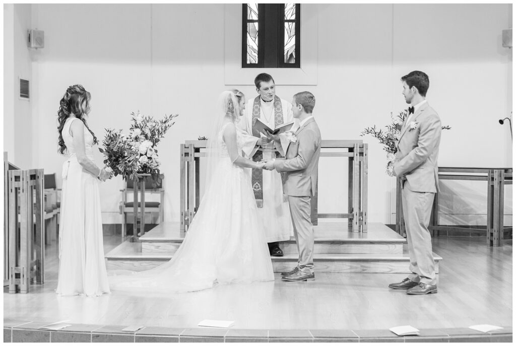 bride and groom holding hands during church ceremony in Dublin, Ohio