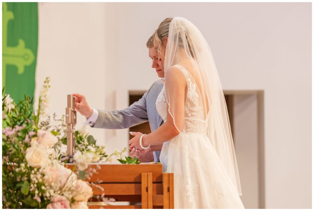 wedding couple have a silent prayer together at the end of church ceremony in Dublin, Ohio