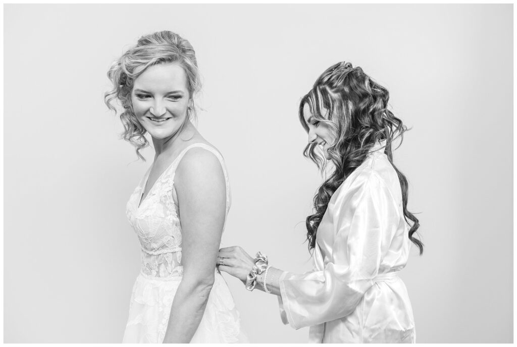 bride's maid of honor zipping the bride's dress at Dublin, Ohio church wedding