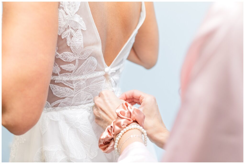 bride's maid of honor zipping the bride's dress at church wedding in Dublin, Ohio