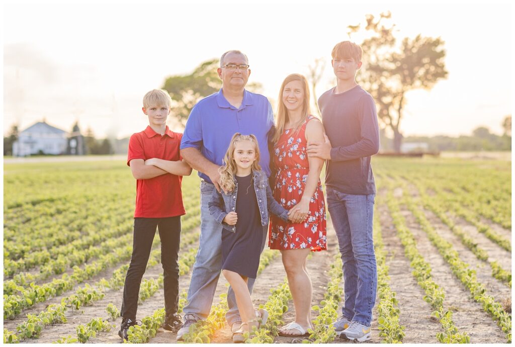 family standing in a farm field with crops for Fremont, Ohio session during sunset