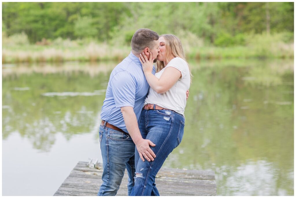 couple bending back for a kiss while standing on a dock in northwest Ohio