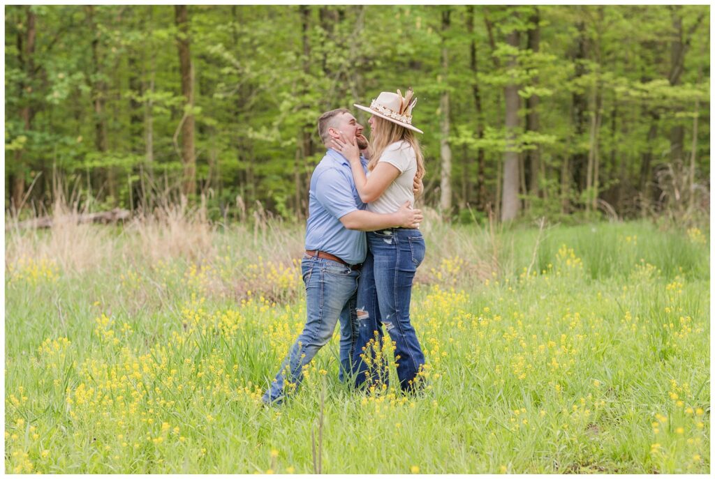 engagement couple posing in a yellow flower field in Willard, Ohio