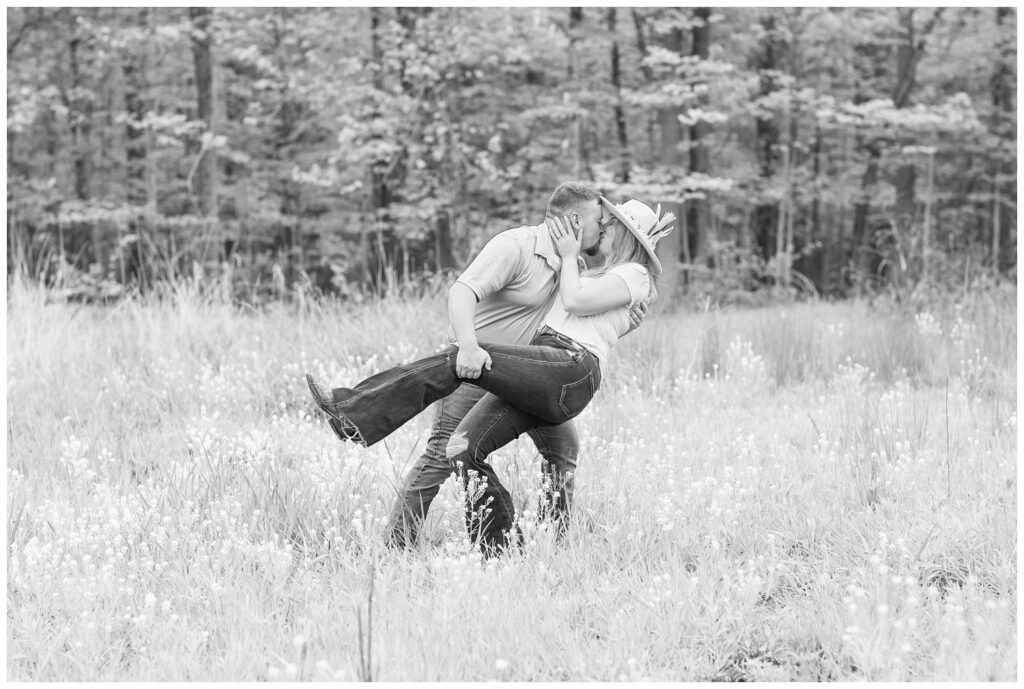 man dipping back his fiance for a kiss in a flower field in Sandusky, Ohio