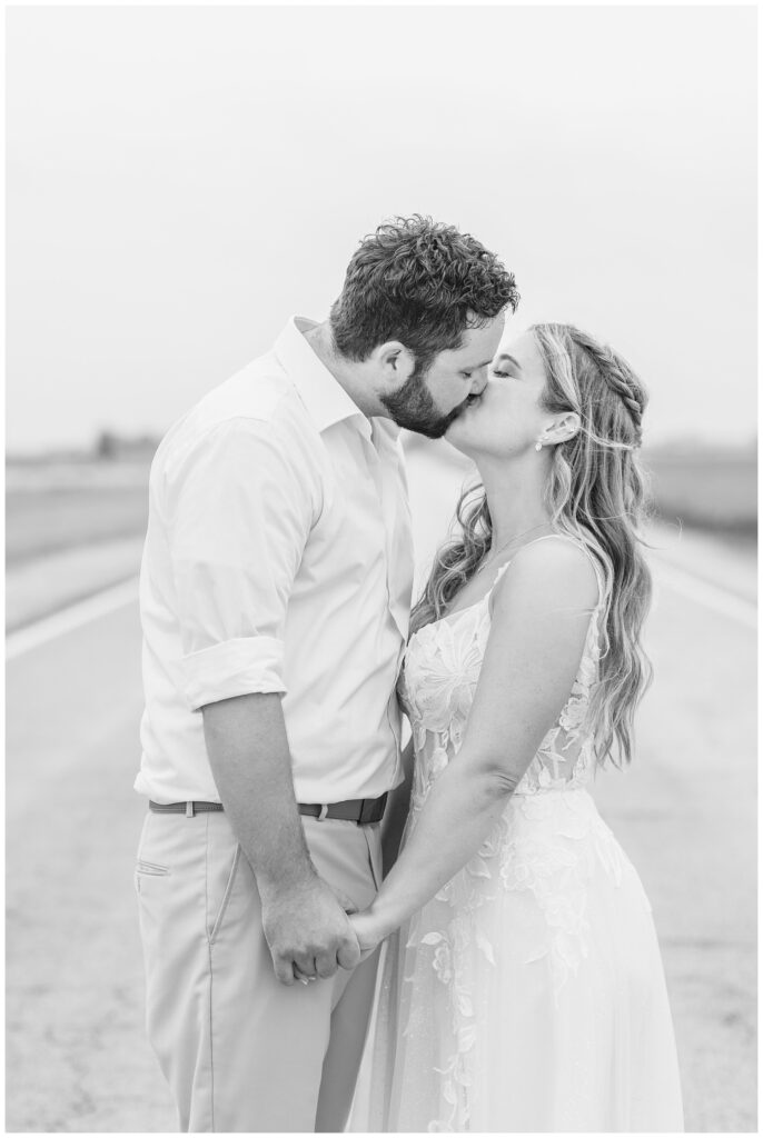 wedding couple sharing a kiss next to a field in Risingsun, Ohio