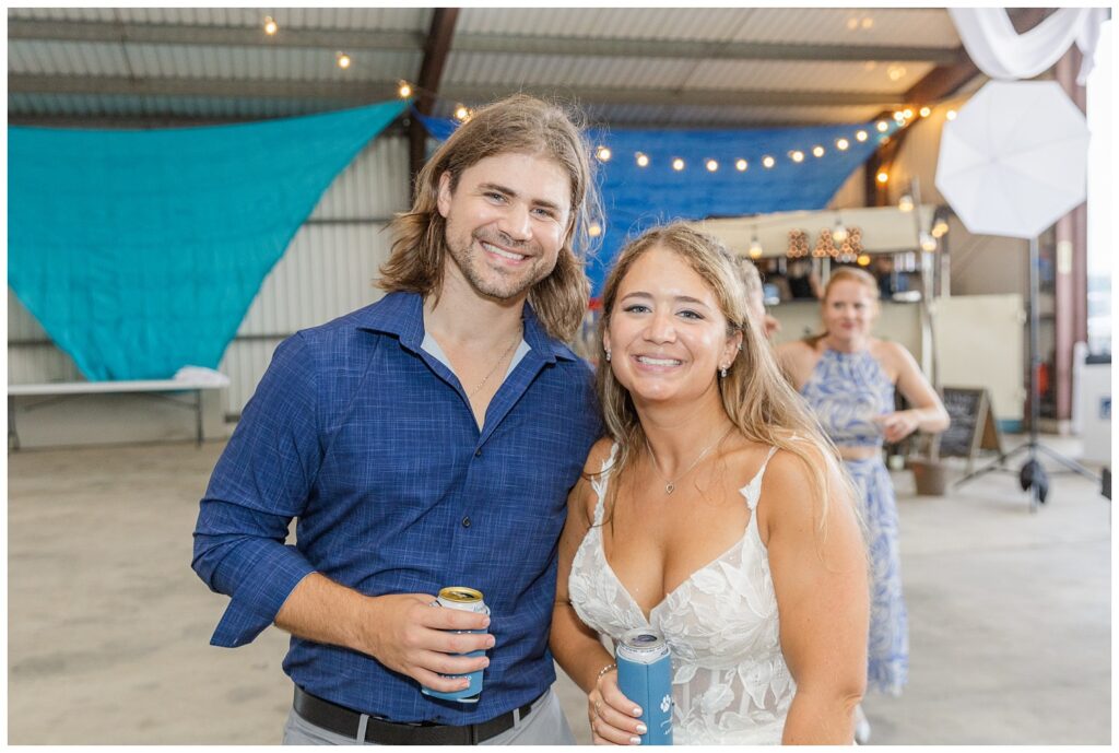 bride posing with her brother at Ohio wedding reception at family farm