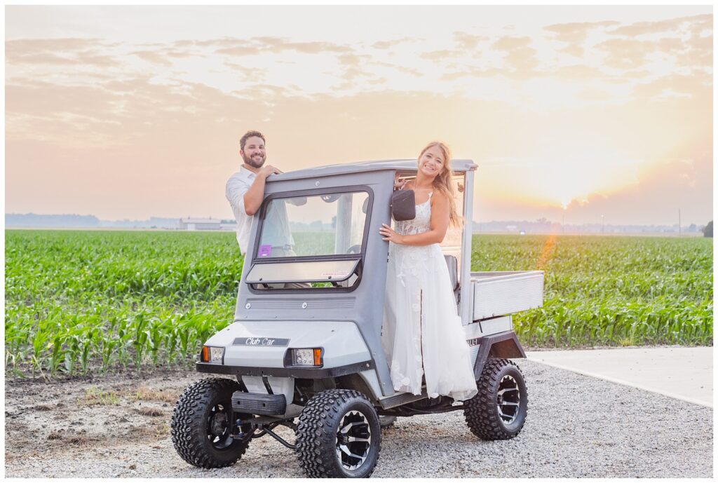 bride and groom standing inside a farm golf cart next to a corn field in Ohio