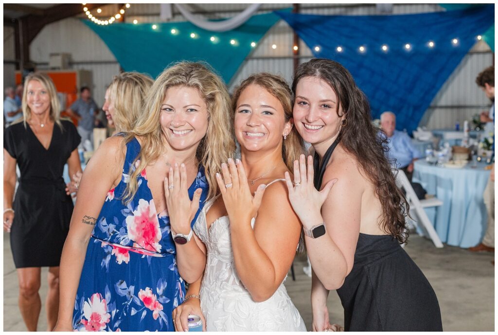 bride and her friends showing off their wedding rings at country reception in Ohio