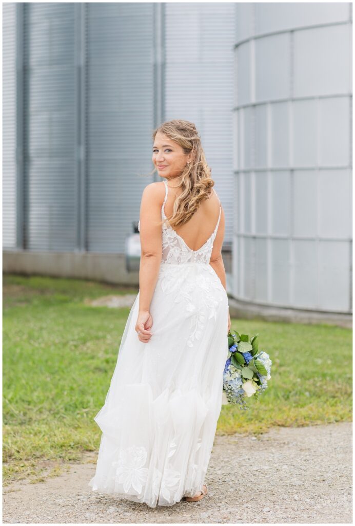 bride posing in front of a silo on a family farm in Risingsun, Ohio