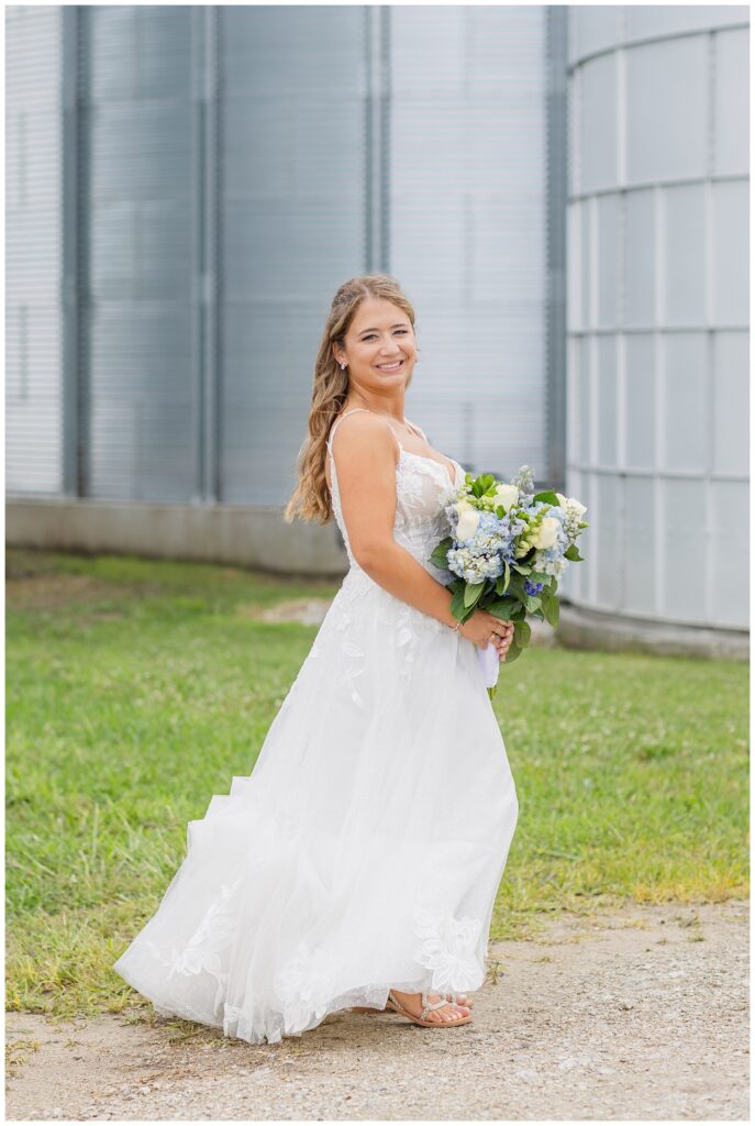 bride posing in front of a silo on a family farm in Risingsun, Ohio