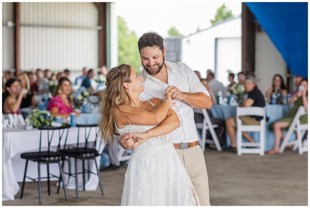 groom dips back bride during first dance at country wedding reception